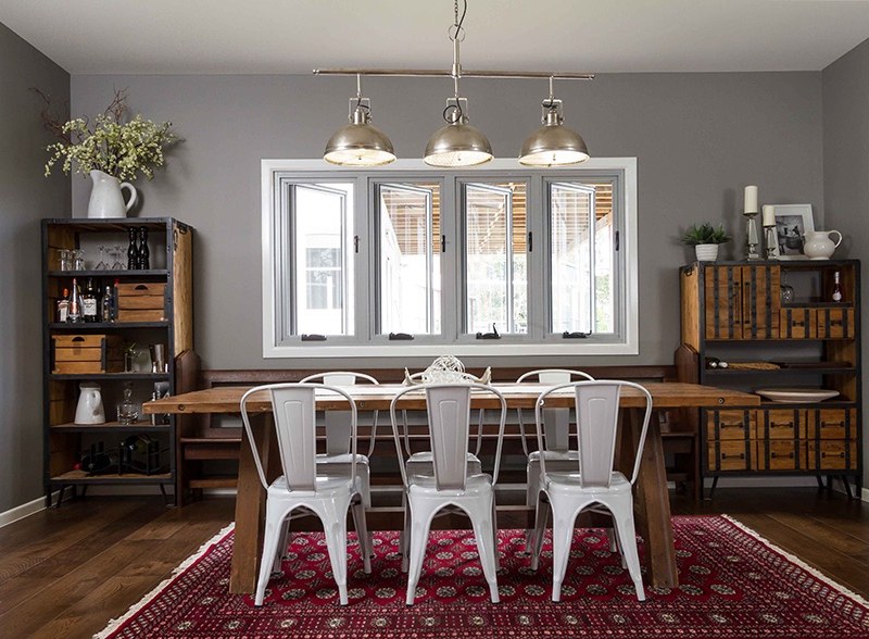 Dining room lit by three brushed-metal pendant lights over a timber table