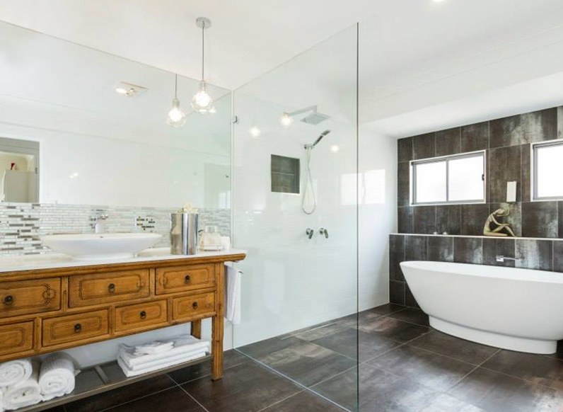 Bathroom with freestanding bath, pendant lighting and timber vanity