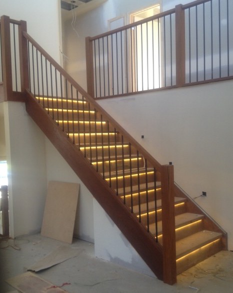 Timber staircase with warm LED strip lighting recessed into each tread